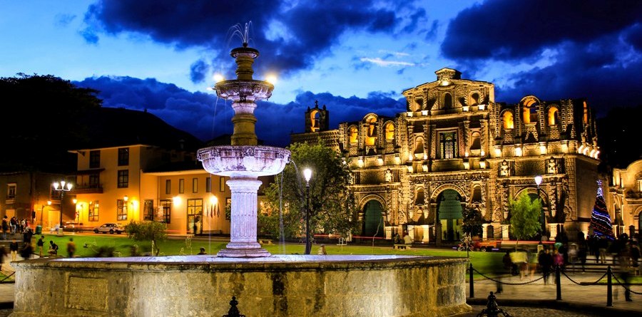 Pileta y fachadas de la Plaza de Armas de Cajamarca al anochecer